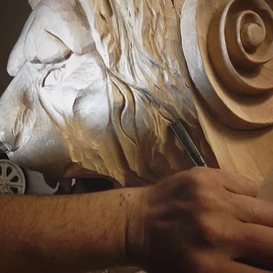 Alexander Grabovetskiy's custom wood carving of a lion's head and scroll in limewood, shown mid-carving.
