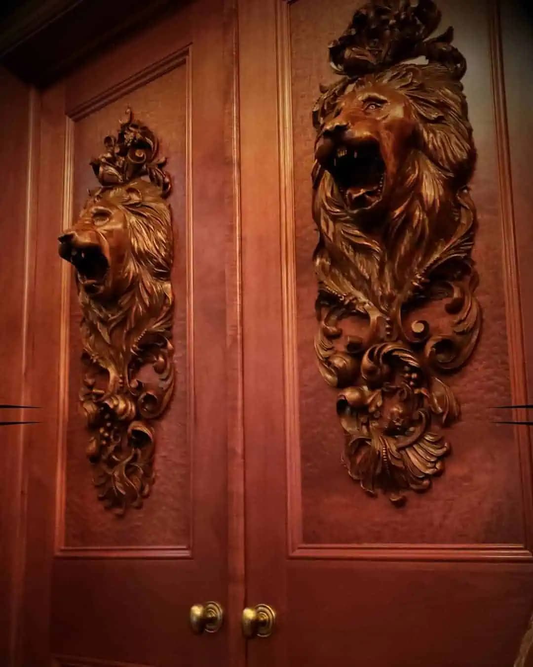Pair of carved lion-head door panels by Alexander Grabovetskiy, a custom wood carving mounted on paneled doors.