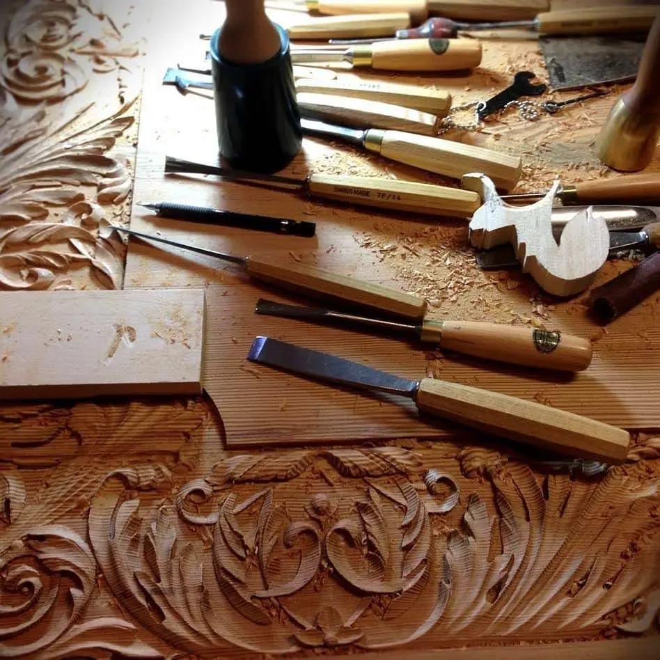 Carved acanthus scrollwork panel with chisels and gouges by Alexander Grabovetskiy, a custom wood carving in progress.