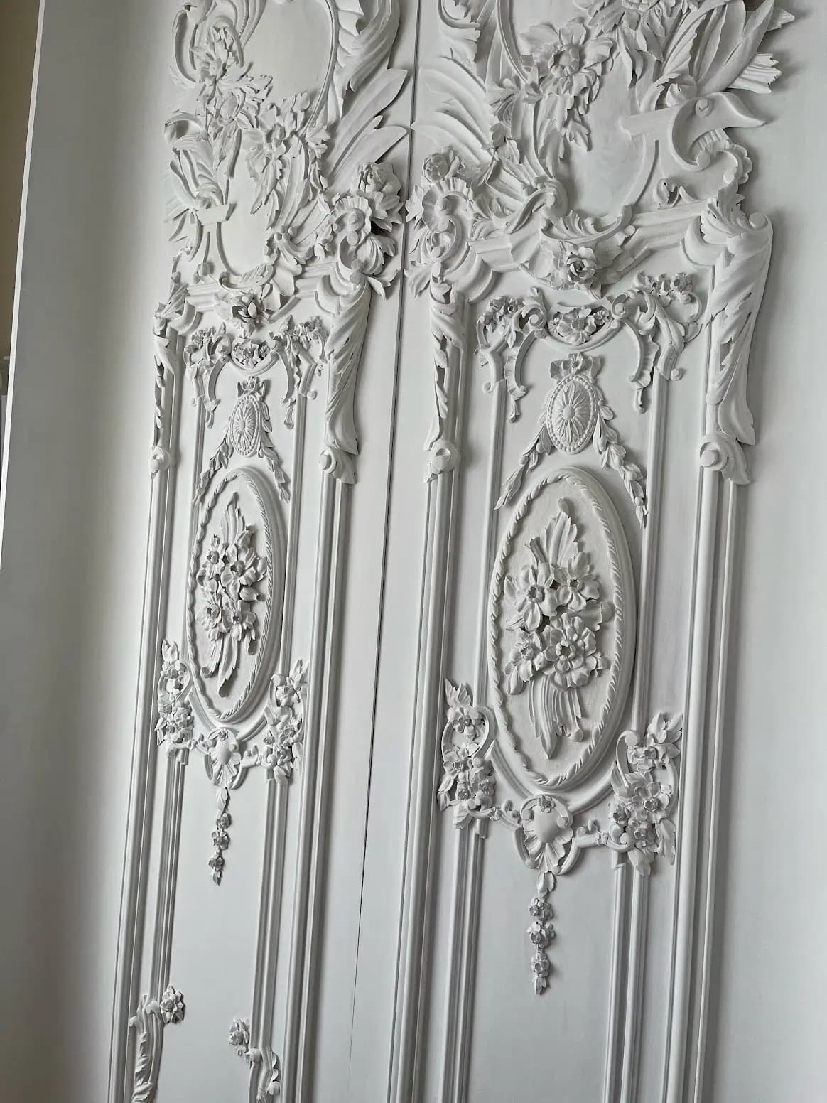 Ornate white carved wall panels with floral medallions and acanthus scrolls by Alexander Grabovetskiy, custom wood carving.