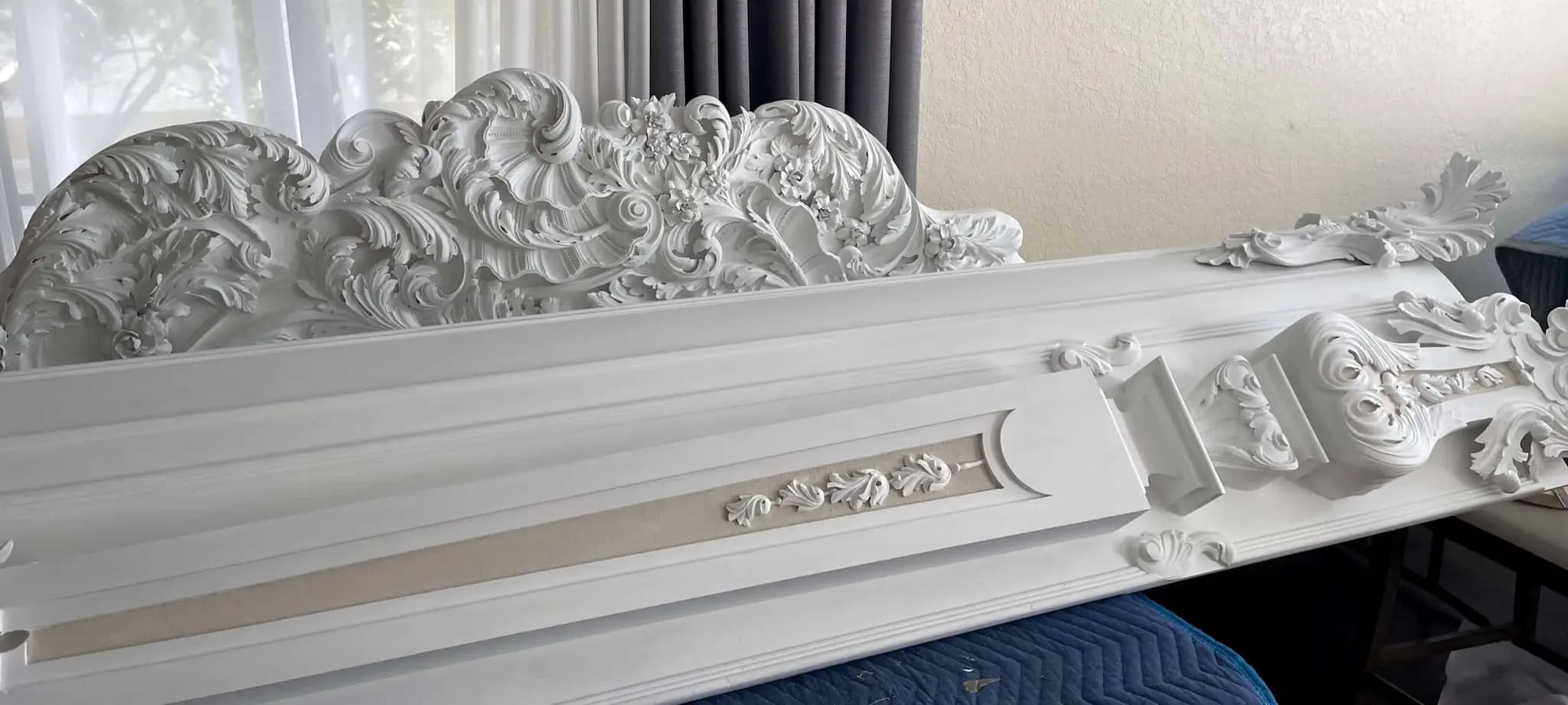 White-primed Rococo crest with a cherub face and acanthus scrolls, a custom wood carving by Alexander Grabovetskiy.