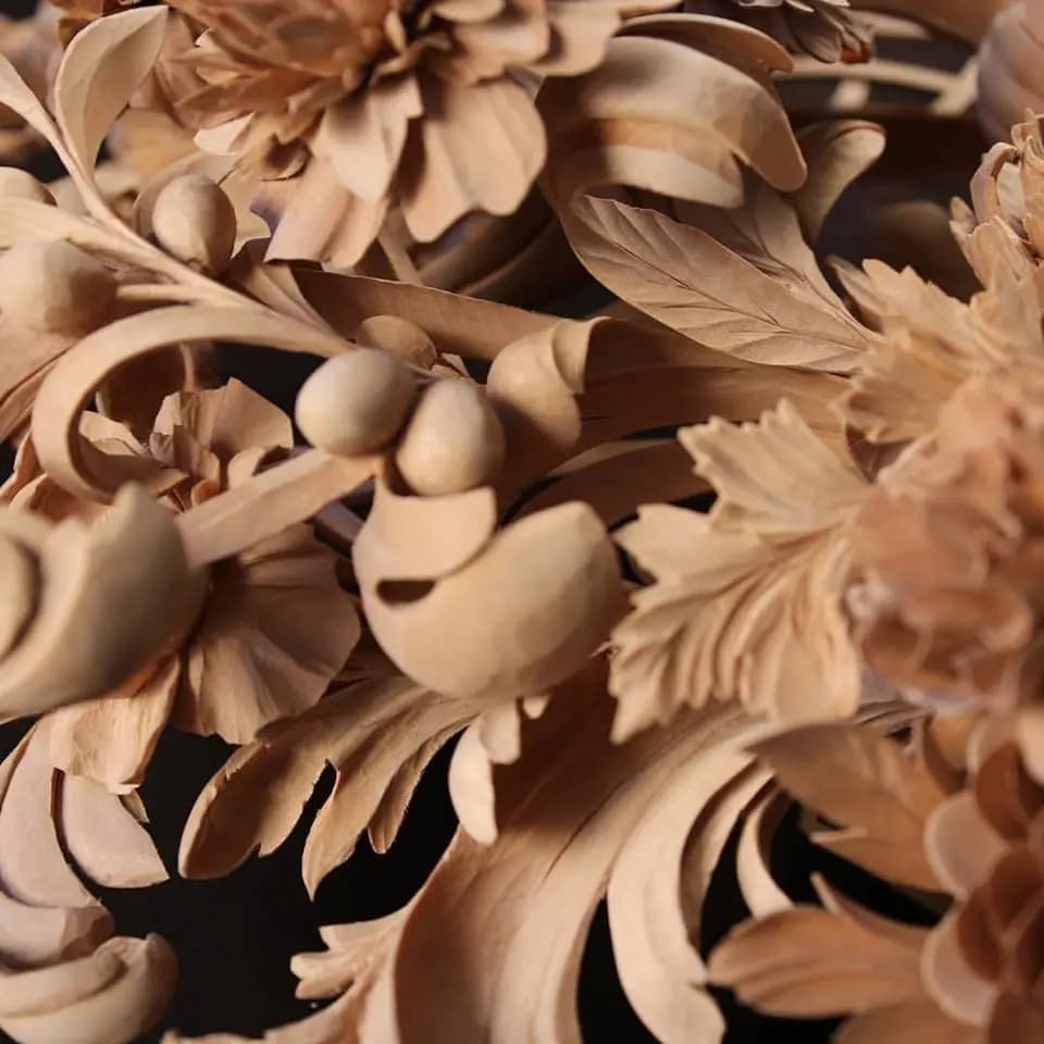 Deeply carved limewood chrysanthemums, berries, and leaves by Alexander Grabovetskiy, a custom wood carving detail.