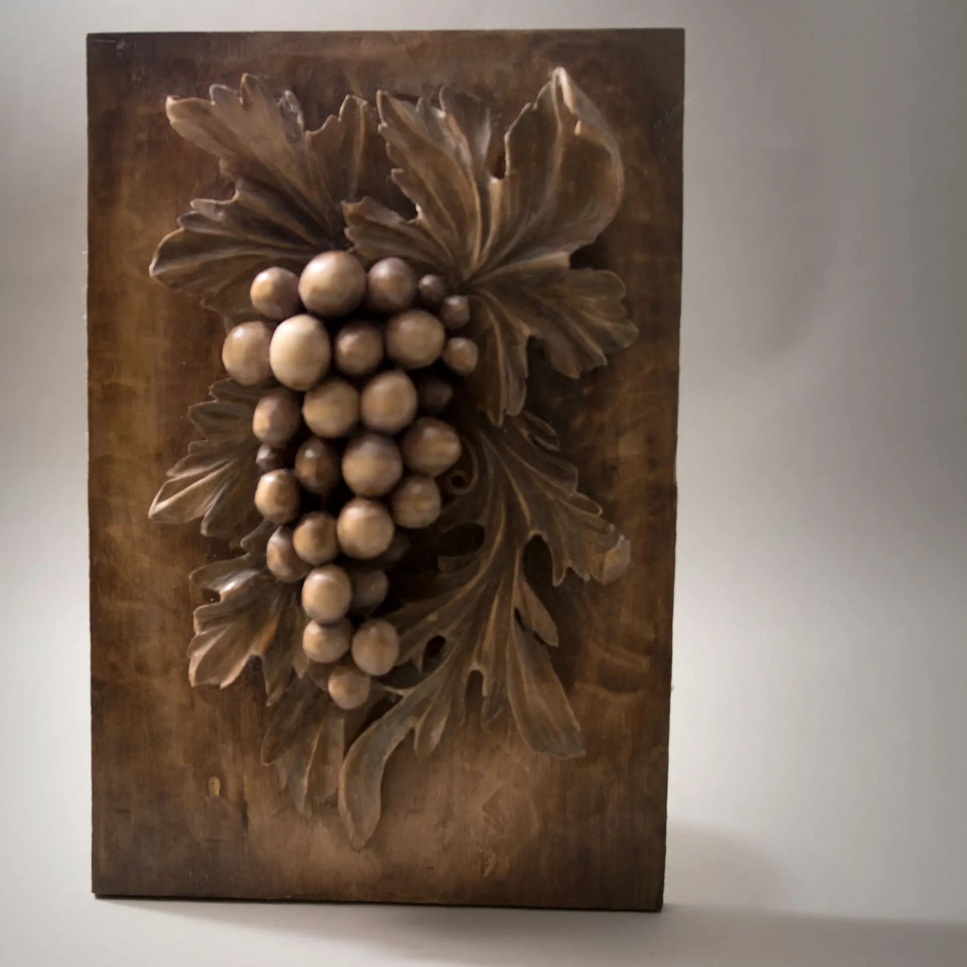 Deep relief grape cluster and vine leaves, a custom wood carving by Alexander Grabovetskiy in limewood.