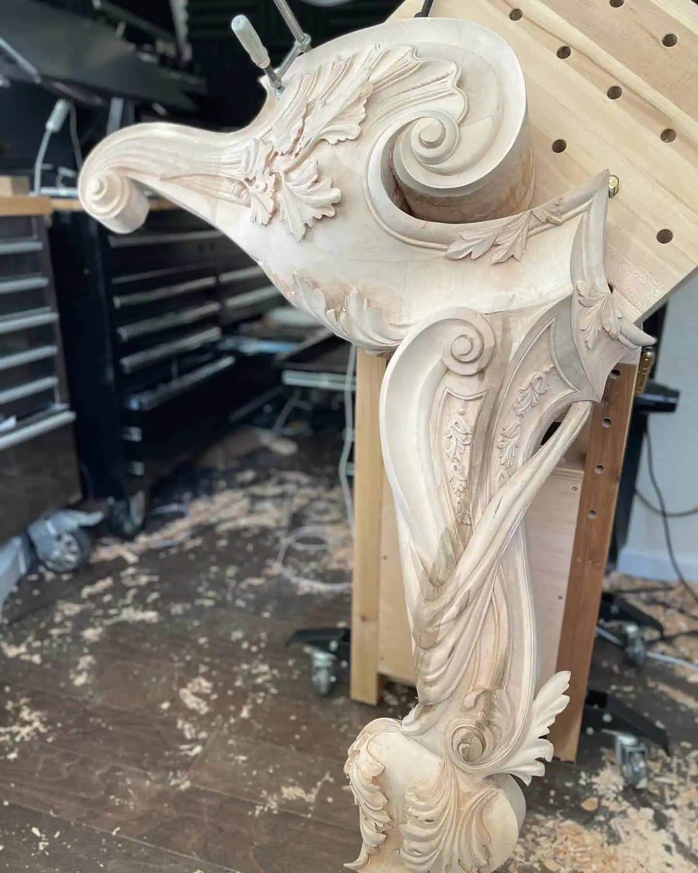 Limewood console bracket with acanthus scrolls, a custom wood carving by Alexander Grabovetskiy in progress on the bench.