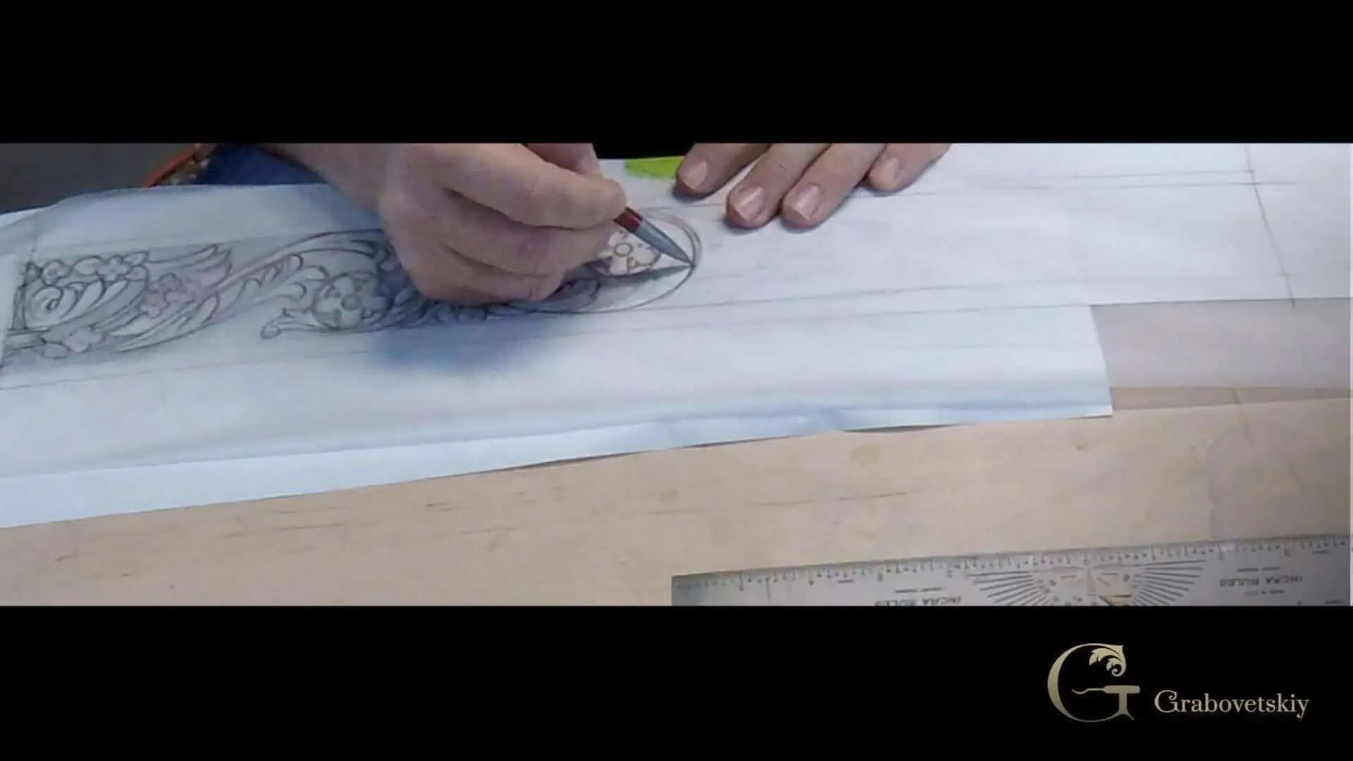 Alexander Grabovetskiy drawing an acanthus scroll pattern on paper, preparing a custom wood carving design.